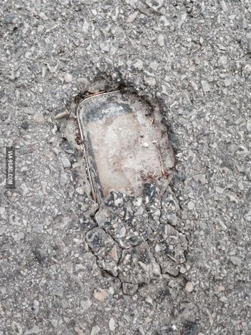 Nokia enterrado en asfalto