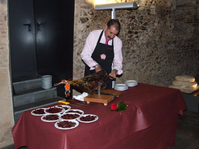 Un cortador presentando unos platos con cecina de León. 