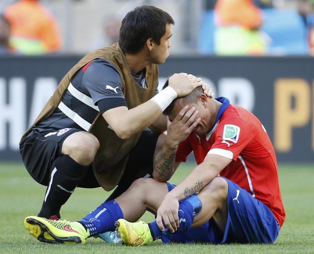 Chile's Medel is comforted by goalkeeper Herrera after losing their 2014 World C