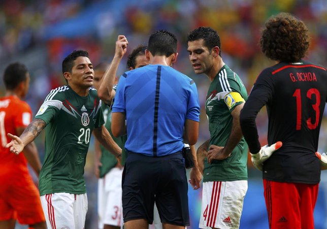 Mexico's players discuss with referee Proenca of Portugal after he called a pena