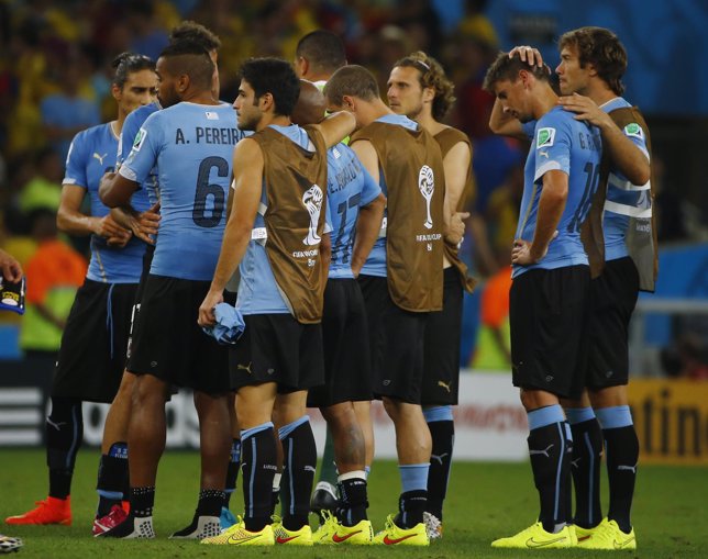 Uruguay's national soccer players react as they console each other after losing 