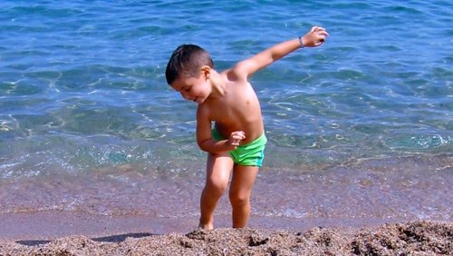 Un niños en la playa con una pulsera identificativa