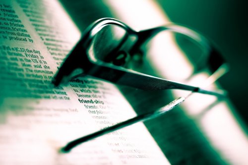 Foto de recurso de un diccionario en inglés y unas gafas