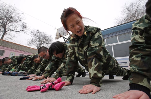 Students receive a group punishment during a military-style close-order drill cl