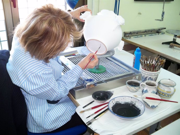 Ceramista trabajando en una pieza de cerámica en el Taller Escuela de Muel