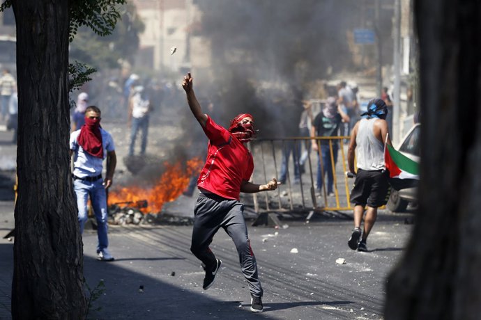 Palestino lanzando una piedra en enfrentamientos en Jerusalén