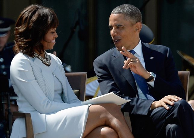 President Barack Obama (R) speaks with his wife fir