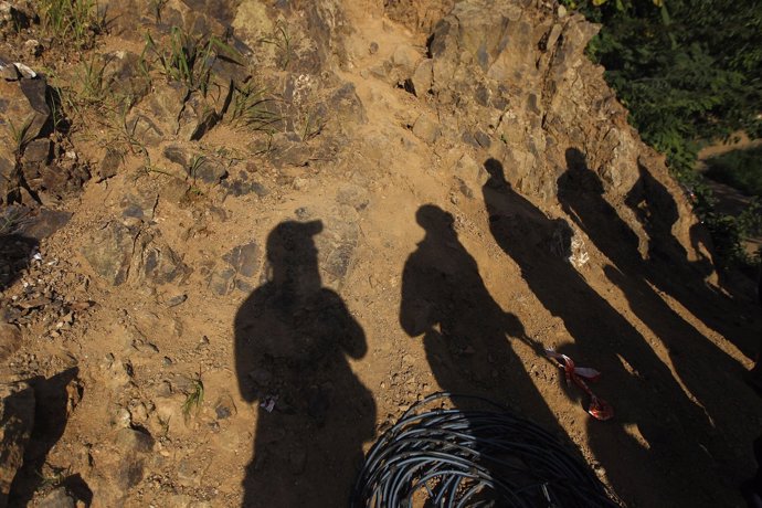 Soldiers cast their shadows as they guard the road access to a gold mine affecte