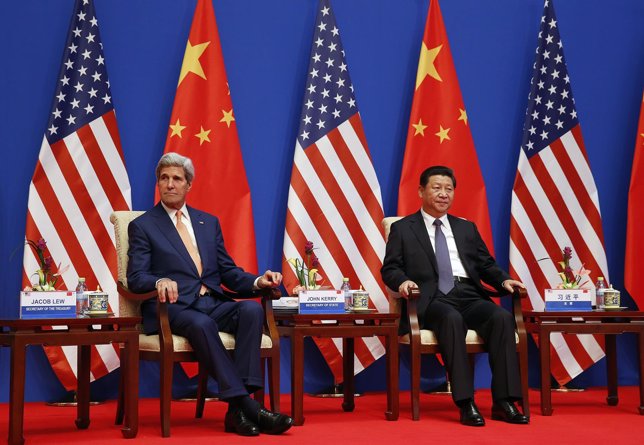 U.S. Secretary of State Kerry and China's President Xi sit next to each other as