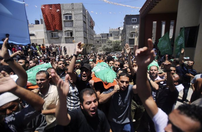 Mourners carry the bodies of Palestinian members of al-Haj family, who medics sa