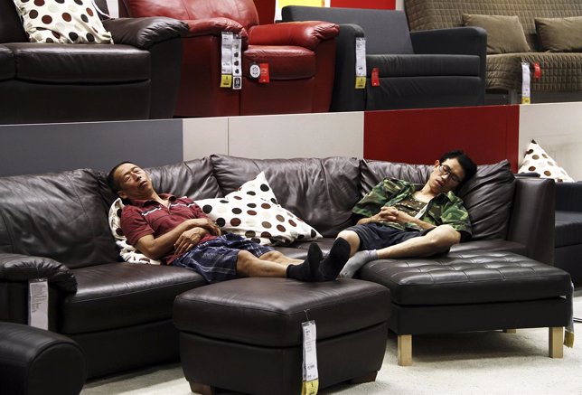 People take a nap on a couch at an IKEA store to escape the summer heat in Beiji