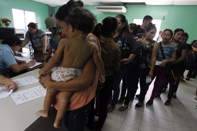 Women and their children wait in line to register at the Honduran Center for Ret