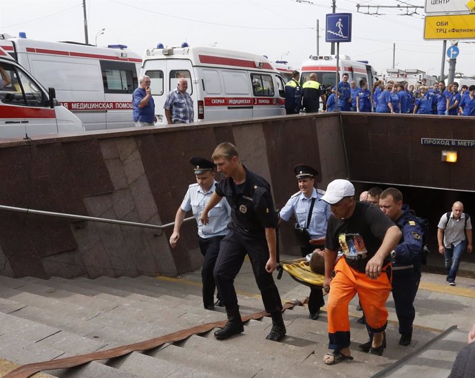 Bomberos trasladan a un herido por el descarrilamiento del metro de Moscú