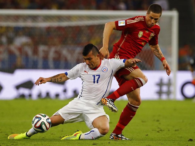 Chile's Medel and Spain's Torres fight for the ball during their 2014 World Cup 