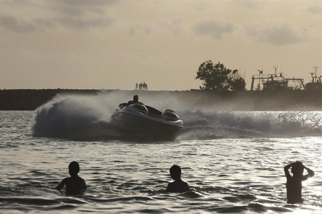 A man drives a boat on the weekend at the beach of Benghazi