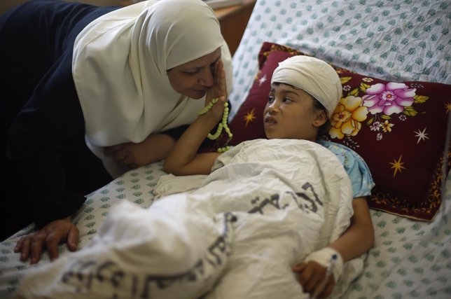 Una madre palestina consuela a su hija herida en Gaza