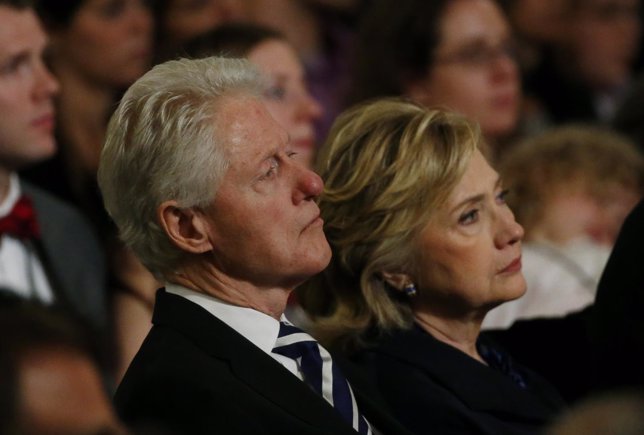 Former U.S. President Bill Clinton sits with his wife former U.S. Secretary of S