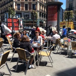 Personas en terraza, comiendo, bebiendo, buen tiempo, turismo, turistas