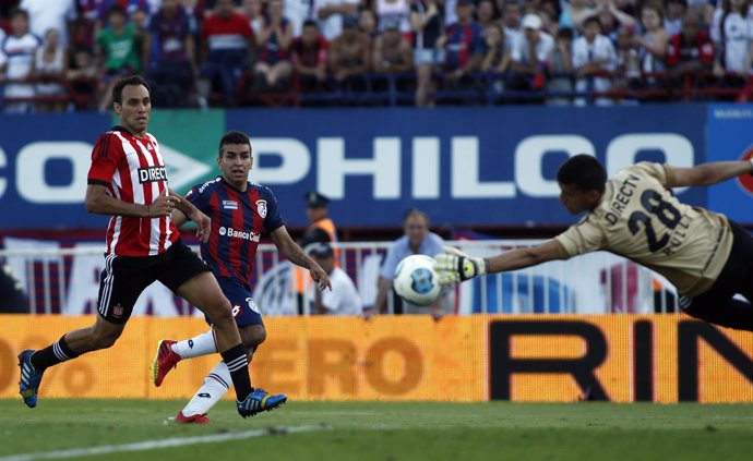 Estudiantes' goalkeeper Rulli blocks a shot from San Lorenzo's Correa, while Est