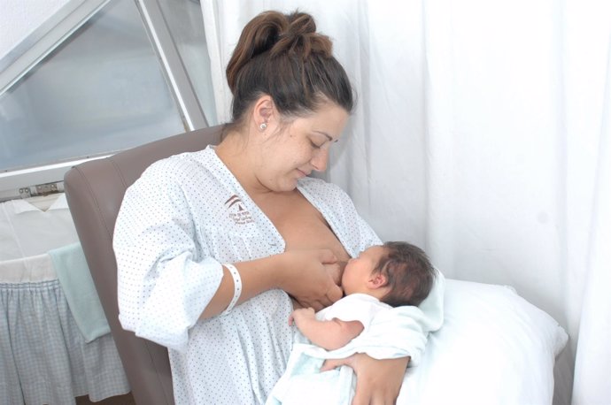 Una paciente da el pecho a su hijo recién nacido