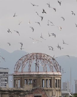 Doves fly over the gutted Atomic Bomb Dome during a ceremony at the Peace Memori