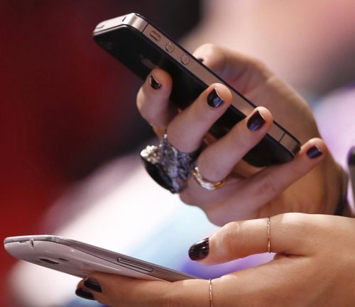 Una mujer usa un smartphone, Facebook