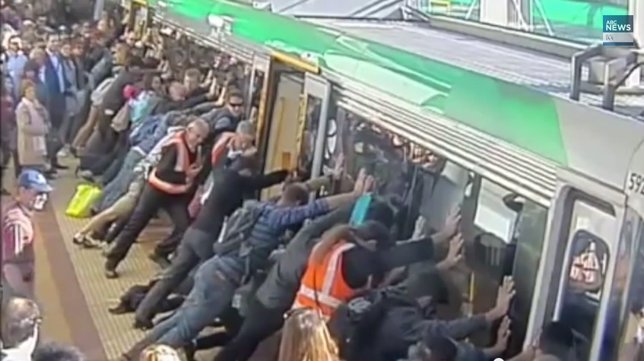 Decenas de personas empujan un tren para liberar a un pasajero atrapado