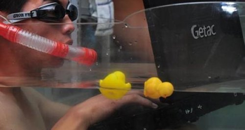 Ciudadano chino jugando al ordenador en una piscina hinchable