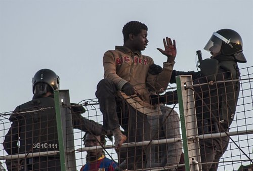 Inmigrante africano discute con la Guardia Civil española en la valla de Melilla