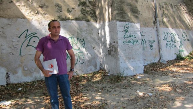 El concejal de IU, Raúl Ariza, delante de una pintada en la ribera del Ebro