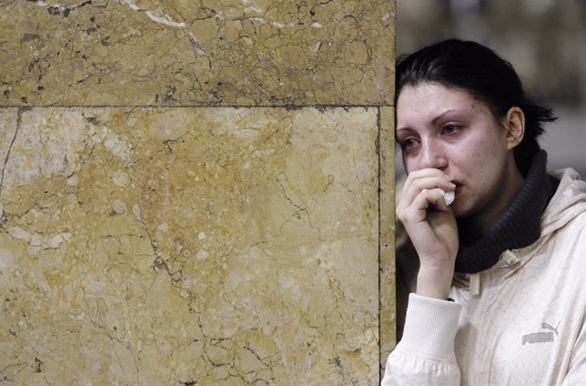 A woman cries at Park Kultury metro station in Moscow