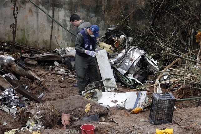 Rescue personnel survey the wreckage site of the crashed private jet which was c