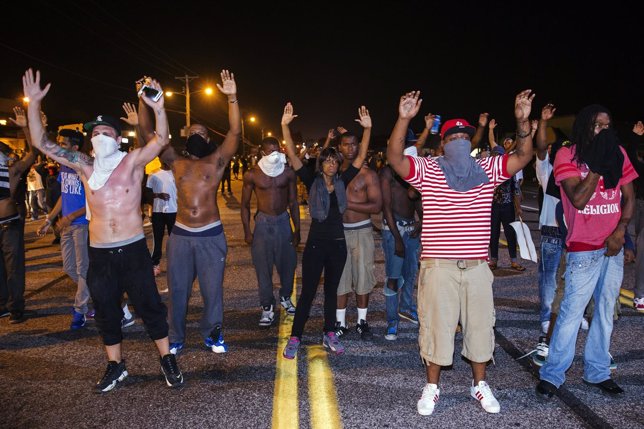 Manifestantes en Ferguson alzan las manos en señal de protesta por Michael Brown