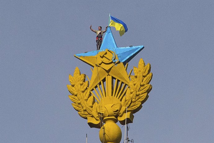 Un hombre ondea la bandera ucraniana en lo alto de un edificio de Moscú