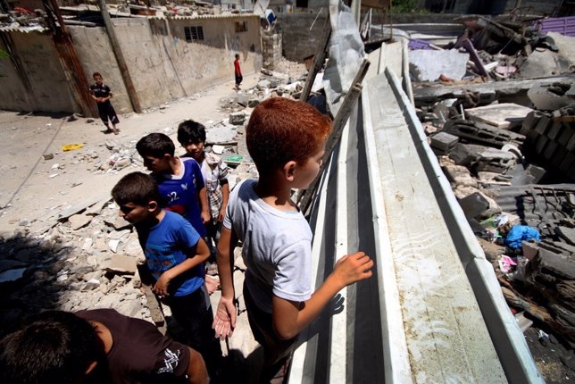 Niños merodean en los alrededores de sus viviendas destruidas en Gaza