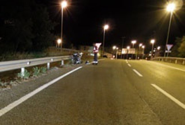 Un agente de la Policía Foral examina la moto accidentada. 