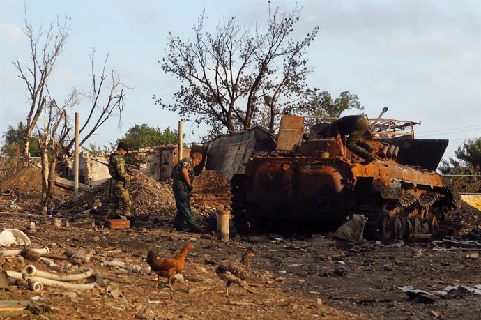 Separatistas prorrusos junto a un tanque ucraniano quemado