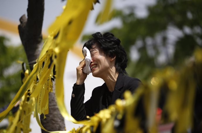 Mujer llora frente a un altar dedicado a las víctimas del Sewol