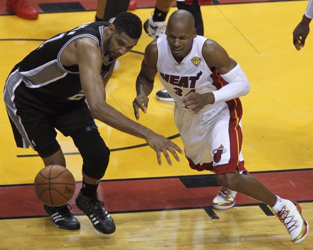 San Antonio Spurs' Tim Duncan chases a loose ball with Miami Heat's Ray Allen du