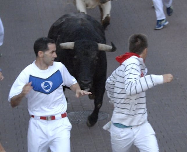Mozos corren delante del toro en los encierros de San Sebastián de los Reyes