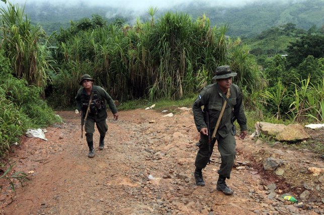 Army soldiers walk near the site of a landslide at a gold mine, at the El Comal 