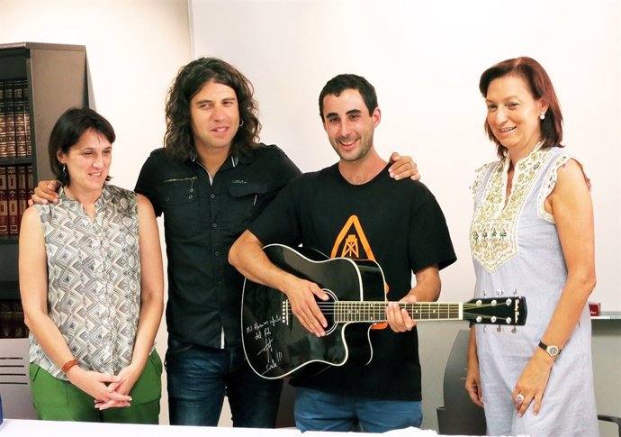 Rulo entrega una guitarra al ganador de un sorteo de la AECC