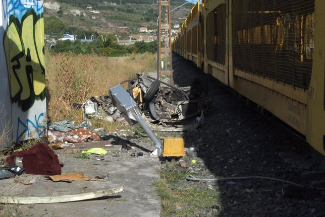 Los restos del coche, junto al tren implicado en el suceso.