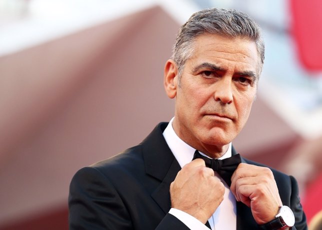 U.S. Actor George Clooney adjusts his bowtie as he arrives 