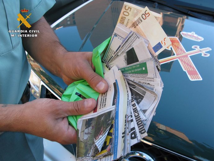 Recortes de periódico que se hacen pasar por billetes en el timo