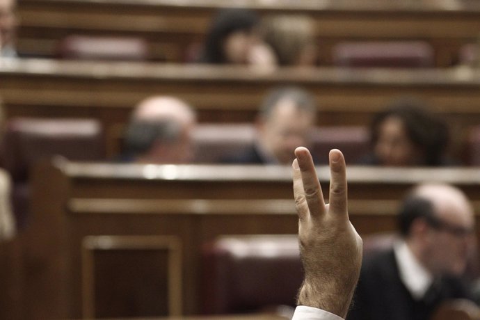 Mano marcando votación a los diputados en el hemiciclo