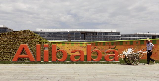 Un trabajador pasa junto al logo del grupo de internet Alibaba