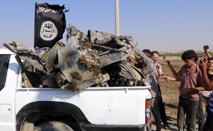 Milicianos del Estado Islámico recogen los restos del avión derribado