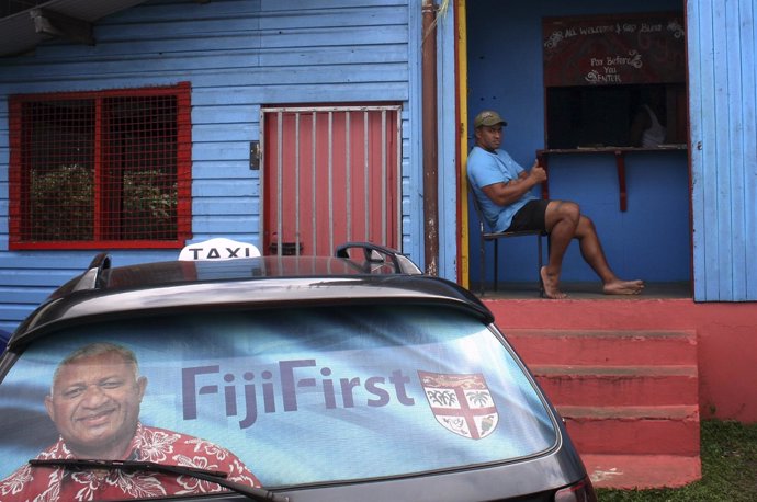Election poster for Bainimarama can be seen in the rear window of a taxi as a ma