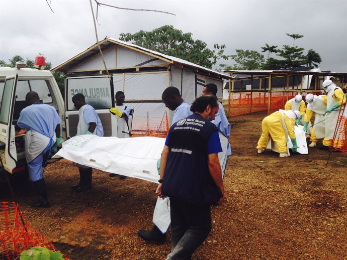 Voluntarios cargan con el cuerpo de una víctima del ébola